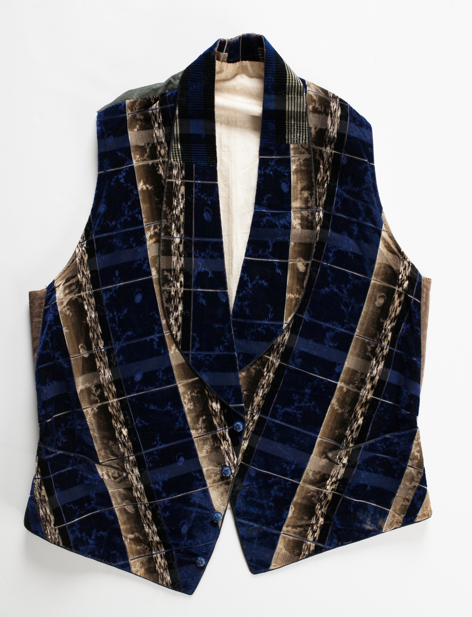 Blå/beige/brun rutig blomranksmönstrad sidensammet. Framsyckena är vadderade. Sammeten är mönstrad i skuren och oskuren sammet med värmeetsad skuren sammetslugg som bildar blomsterrankorna. Ripsbindning bildar rutorna. Vikt skarvad schalkrage och fyra blå trådklädda knappar i silke i öppning framtill. Infällda fickor på båda framstyckena. Tunt svart vaxat bomullstyg i bakstycket med slejf och metallspänne. Helfodrad med ljust linnefoder i tuskaft. Skodd med gröna skinnremsor på insidan av framkanternas nederkant.