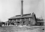 Gefle Glasbruk omkring 1910.
Byggnader från vänster:
1. Stora magasinet
2. Mängkammaren
3. Hyttan
4. Stallet
Personer från vänster:
1. Sigfrid Nangtler, kusin till disponent Anderssons barn.
2. Disponent Wilhelm Andersson.
3. Hyttmästare Iwar Svensson.
4. Körkarlen Karlsson.
Och framför dubbelporten står arbetaren Johannesson med sin yngste son Helmer framför sina ben.
I gruppen av barn längst till höger framför hyttan står från vänster. disponentens son Gunnar och efter honom Johnnessons son Henning.
I potatislandet längst till höger på bilden leker två små flickor, varav den ena är dotter till disponent Anderson.