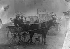 I vagnen sitter Johan Axel Hullander född 1863 i Strömsbro. Hullander utvandrade  på 1880-talet till  Melbourne, Australien och arbetade bl.a. vid gasverket i Mellbourne. Bilden förmodligen tagen i ateljé någonstans i Australien.