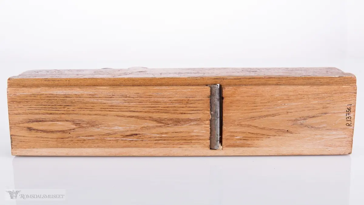 Rektangulær høvel med jern og kile. Har et spor på siden av sålen.