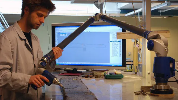 Arkeologene 3D-dokumenterer hver enkelt båtdel. Arkeolog dokumenterer hudbord med FARO-arm.