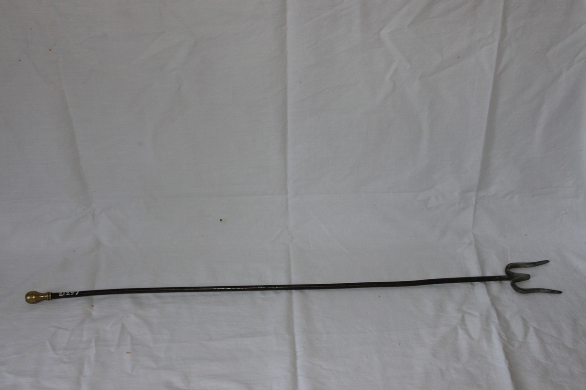 Skopa av plåt, rundbukig med 14 cm långt kupat skaft avslutat med en krok. I skaftet stämplat ESKILSTUNA STÅLFABRIKS AB 1L