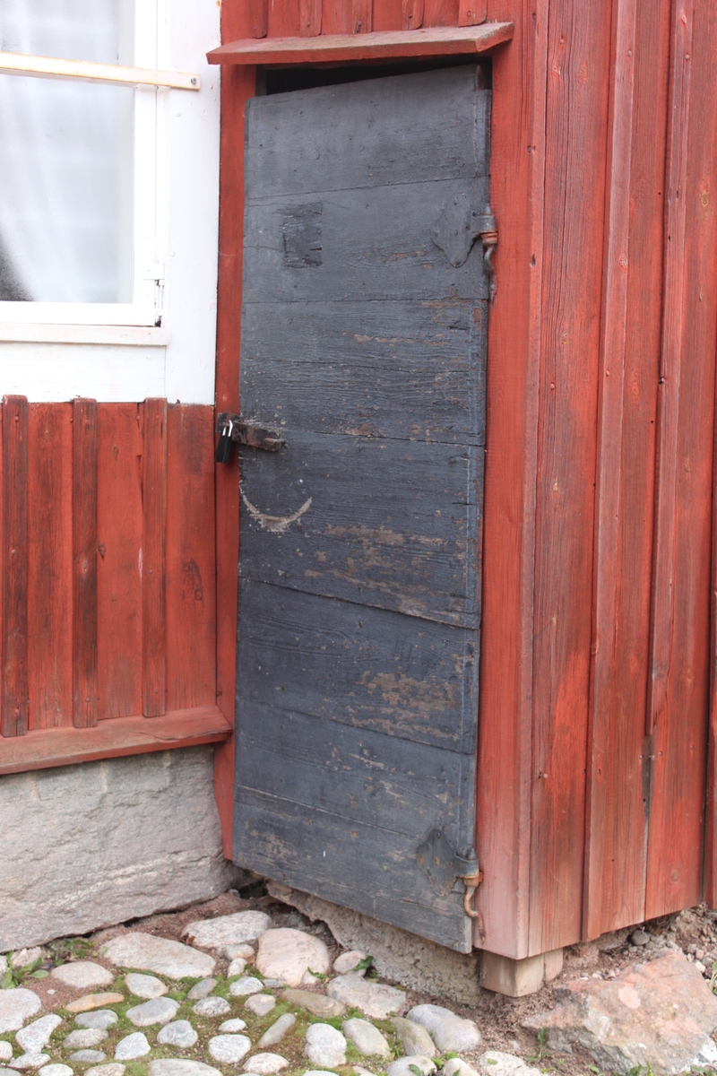 Byggnaden innehåller två bostäder om ett rum och kök samt förråd. Den står på en grund av huggen sten och är uppförd i liggande timmer med utknutar och knutlådor. Byggnadens nedersta våning är delad av ett portlider. Fasaden är delvis klädd med locklistpanel på bostadsdelen och uthusdelen, västra och östra fasaderna. På övervåningen inbyggd svalgång åt väster, täckande nästan hela fasaden, med tre luckor och litet fönster med spröjs. Västra fasaden har rödfärgade plankdörrar och luckor, förutom entrédörren till bostaden som är en gulmålad ramverksdörr. Vid portlidrets östra utfart sitter en svartmålad port av plankor, klädd med liggande panel. Spismuren är synlig i västra fasaden. Tegelskorsten med monterat plåtrör på toppen och plåtkant mot taket. Sadeltak liggande på tre åsar, med höjd del över svalgångens bostadsdel. Taket är belagt medenkupigt  tegel. Nock- vatt- och vindskivor är av trä. Mot väster finns hängrännor och stuprör i plåt.