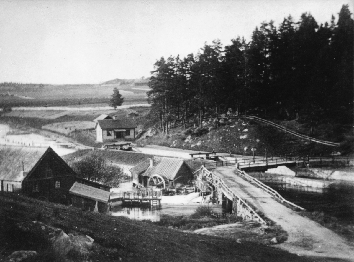 Hjulsbro kvarnar vid Stångån. Platsen där Hjulsbro Tråddrageri & Spikfabriks AB startade. 
Hjulsbro Tråddrageri & Spikfabriks AB bildas 1907, 1921 gick företaget i konkurs. Det rekonsturerades 1923 av Jonn O Nilson och en ny fabriksbyggnad uppförs för nättillverkning. 1930 brinner den gamla fabriken och en ny byggs med modernare utrustning. 1946 uppförs en ny fabriksbyggnad vid Hjulsbro station. 1947 brinner nätfabriken vid ån och en stor del av tillverkningen flyttas till fabriken vid järnvägen. Vid ån uppförs en ny byggnad för förzinkning. 1957 börjar tillverkning av spänntråd.  1975 har all tillverkning flyttats till fabriken vid järnvägen. 1982 flyttas tillverkning och utrustning från Fagersta AB hit och 1985 köper finska Ovako Hjulsbroverken.

Extern information 2018:
Fotot är sannolikt taget på 1870-talet eftersom flera av Kinda Kanals slussar fotograferades vid denna tidpunkt, möjligtvis av samma fotograf (okänd fotograf). Slussvaktarbostaden stod färdig 1871. Stora byggnaden till vänster är Hjulsbro kvarn. Byggnaden mitt i forsen är en "walkverksinrättning" för beredning av textila naturmaterial. Bron över forsen byggdes om till en stenvalvsbro 1895.