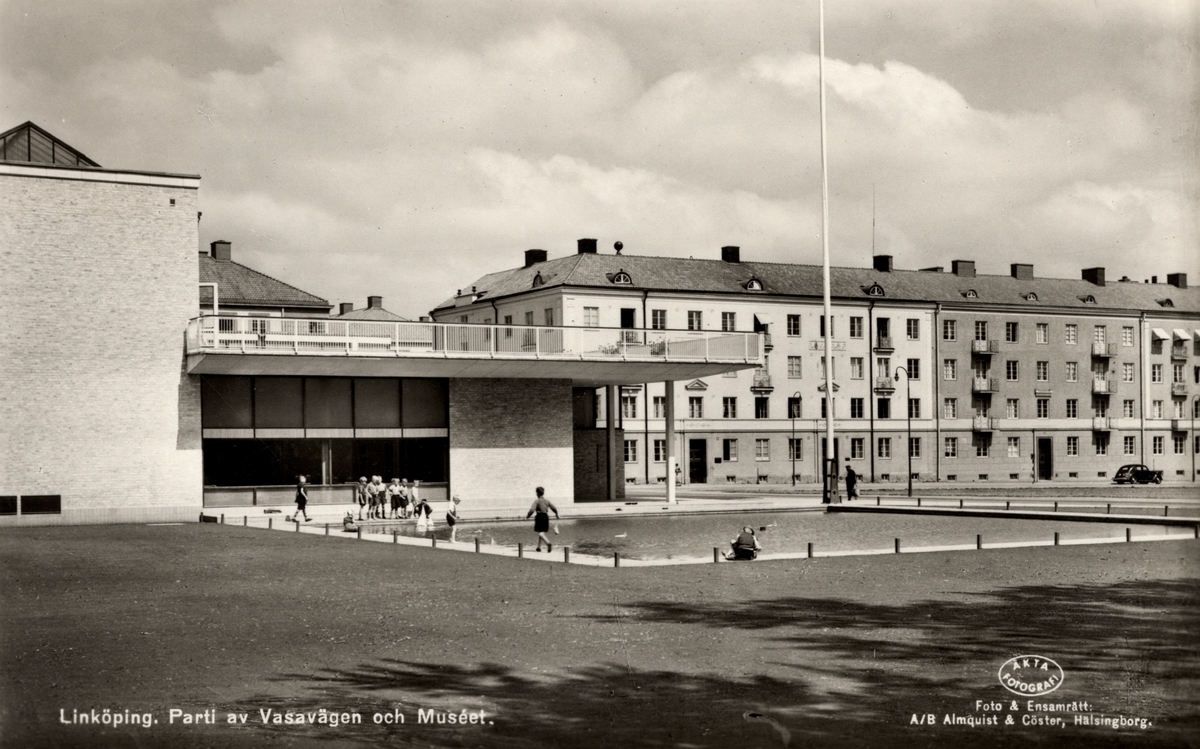 Bildtext: Linköping. Parti av Vasavägen och Muséet.
Plaskdammen vid Östergötlands länsmuseum.

Museibyggnaden är uppförd efter ritningar av Nils Ahrbom och Helge Zimdahl och invigd 1939. Stilen är funktionalism, ett litet avsteg är dock granitfrisen över entrén av Ivar Johnsson.