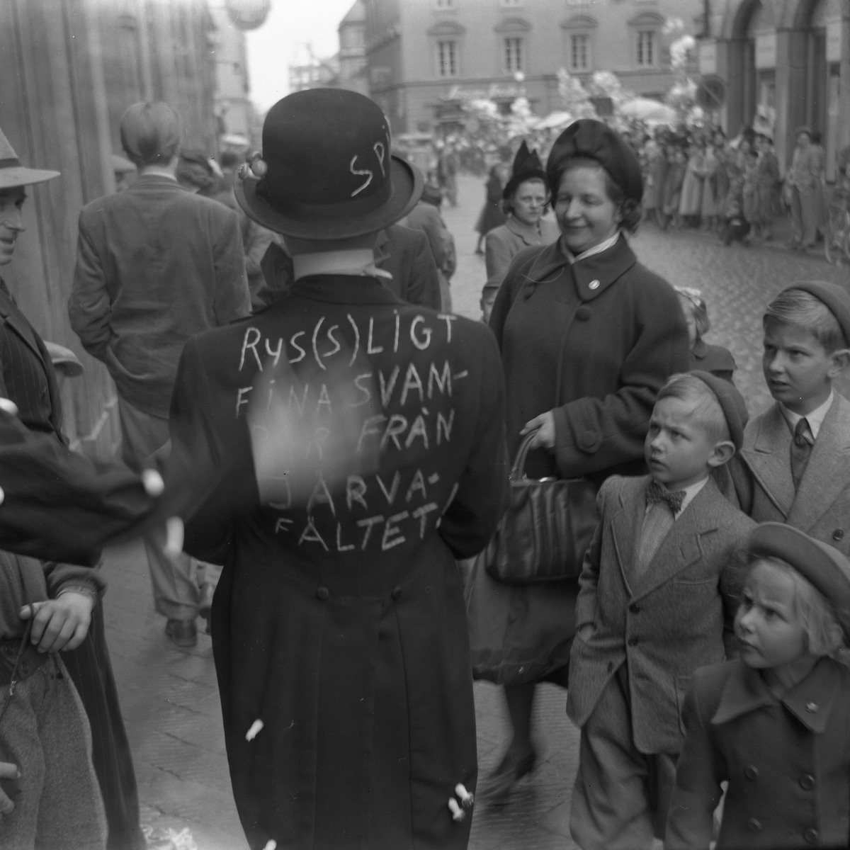 Orig. text: Majkarnevalen 1952.

Majgubbe på Storgatan.