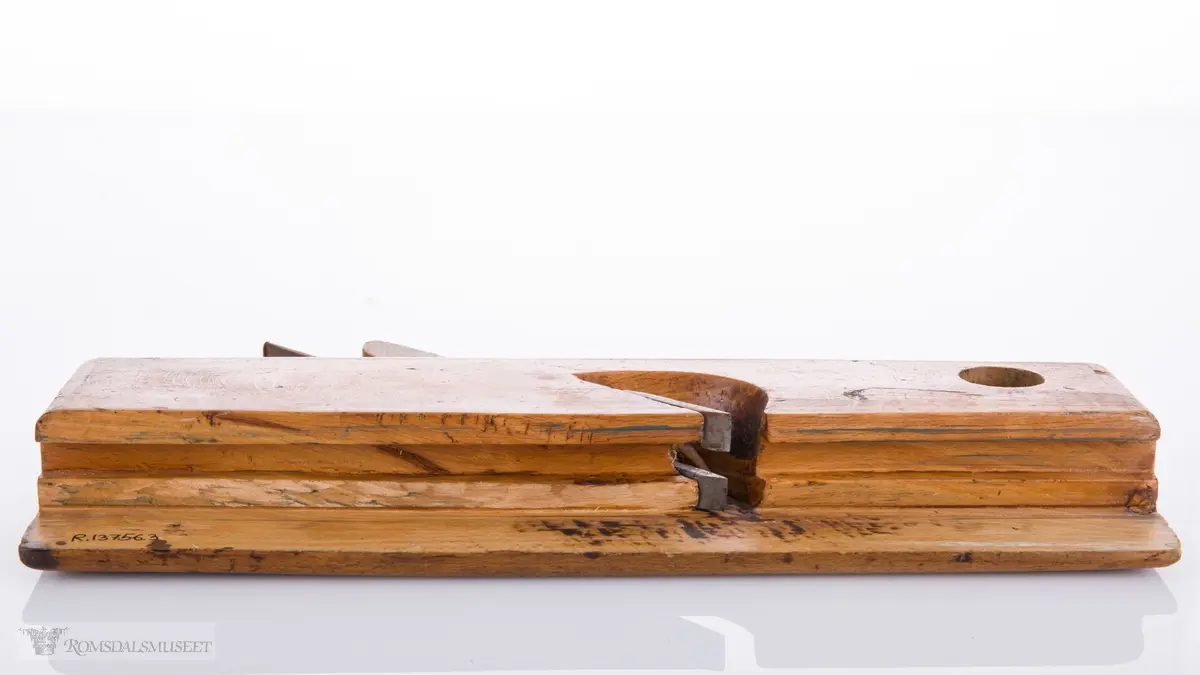 Smal høvel med hesteskoformet jern for høvling av fjær. Den ene siden av høvelen har en støtteskinne.