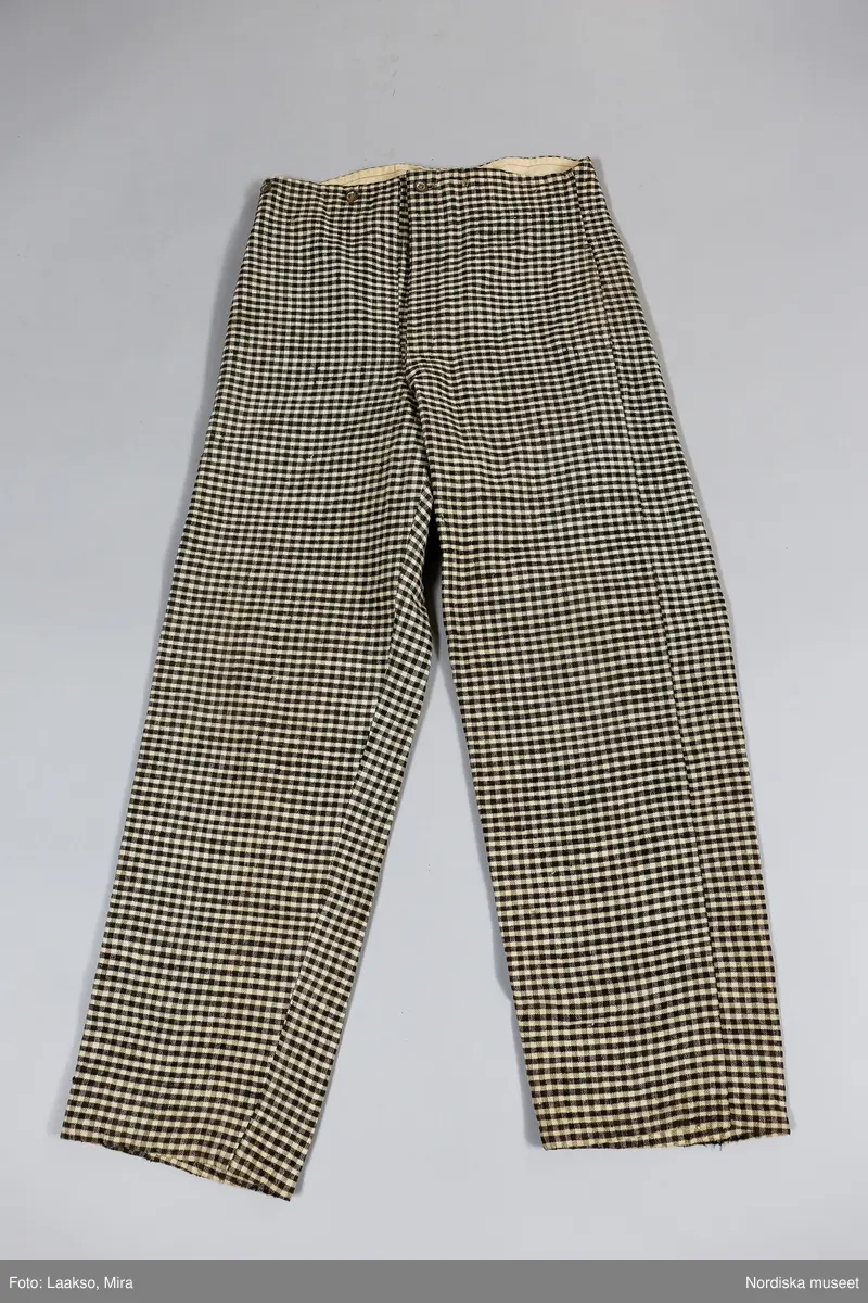 Huvudliggaren (år 1931-1932):
"189354 ab Väst m byxor, från Ösby, Lunda sn, Seminghundra hd, Upland, ylle, smårutigt i svart, grått och vitt; hemspunnet garn och hemvävt tyg, omkr 1860; säljarens svärfaders fästmanskläder; fr. fru Anna Karlsson, Ösby. 25:-"