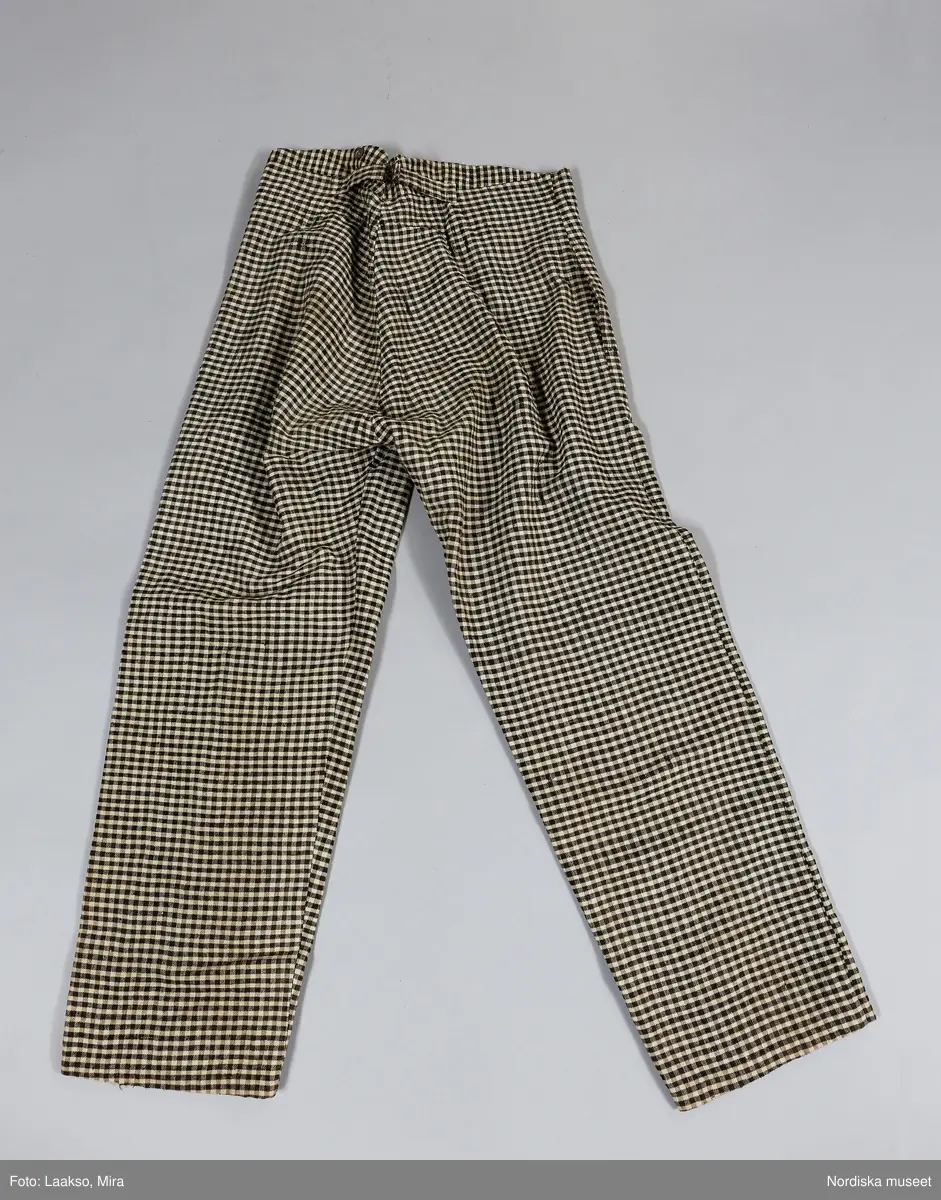 Huvudliggaren (år 1931-1932):
"189354 ab Väst m byxor, från Ösby, Lunda sn, Seminghundra hd, Upland, ylle, smårutigt i svart, grått och vitt; hemspunnet garn och hemvävt tyg, omkr 1860; säljarens svärfaders fästmanskläder; fr. fru Anna Karlsson, Ösby. 25:-"