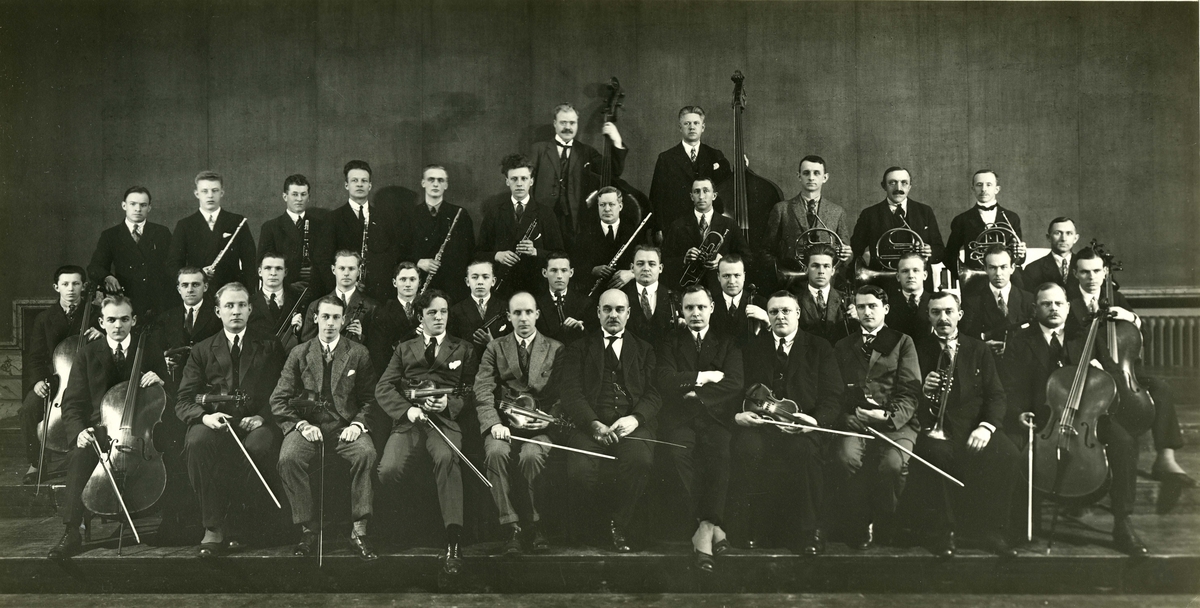 Felleskonsert m/Oslo Handelstands orkester. Se vedlegg.
Fredrikstad Musikkforening felleskonsert med Oslo handelsstands orkester i Logens store sal i Oslo
Avbildet :
1. rekke fv: - Egil Svensen, Rolf Larsen, Conrad Berger, Fridthjof Dahl, Thorleif Windingstad, Severin Svendsen, Jens Bugge Olsen, Aksel Buer, Hans Hansen, Sigurd Johansen, Sigurd Gundersen
2. rekke fra fv: Wilhelm Scwarzott jr., Lars Sætvedt, Ragnar Opsahl, Reidar Bugge Amundsen, Ivar Eliassen, Birger Svendsen, Bjarne Sanengen, Johan Svendsen, Jens Waaler, Harald Pettersen, Rolf Amundsen, ukjent, J. Fr. Coucheron
3.rekke f.v. - Olaf Eriksen, William Hansen, Sverre Simensen, Rolf Jensen, Sigurd Olsen, Harry Marhinsen, Diderik Pedersen, Sigurd Hansen, Herman Kristiansen, Theodor Josefsen, Wilhelm Schwarzott, Olaf Haugen
4. rekke f. v Harald Grimstad, Kjervald Abrahamsen