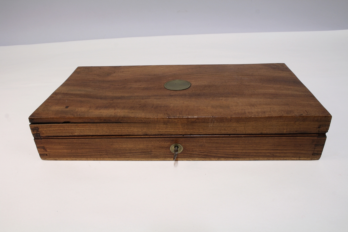 Revolver i "cased set", bestående av revolver (Pepperbox), en enkeltløpet perkusjonspistol samt diverse verktøy, alt liggende i mahognykasse. Bestandelene er følgende: 

KASSE av mahogny, 36,6 x 18,6 x 6,6, cm og er forsynt med lokk som har to mesinghengsler i bakkant. På forsiden er det lås med medding nøkkelhullbeslag på forsiden. Nøkkel av jern, ca. 2,9 cm lang. Midt på lokket er det et rundt messingskilt med profilert kant. Skiltets diameter er 3,8 cm. Kassen er indelt i 11 rom hvorav tre er forsynt med lokk med små, hvite gripehåndtak, runde, knappformede med diameter 1,05 cm. Alle rom er trukket med grønn filt. På lokkets innside er klebet produssentens merkelapp.

REVOLVER. Såkalt "Pepperboks". Et revolverende kammerstykke hvor hver kammer utgjør en selvstendig pipe, en forløper for de senere revolveremed kort tønne og langt løp. Kammerstykket (tønne) er 10 cm langt, hver løp har et kaliber på litt underkant av 10 mm. I bakkant er pipene forsaynt med pistong. På utsiden er pipene ca, 1,2 cm fra pistongene, merket fortløpende med nummer 1 - 6 . Mellom pipene er kammerstykket merket vekselsvis med kronet CP og V. Revolveren har overliggendeslaghane med gravert blomsterranke motiver. Bakenfor hanen er det en bevegelig sikringsfløy. Sideblikkene er prydet med graverte blomsterranker,det venstre sideblikket er markert "W.A. BECHWITH LONDON". Avtrekksbøylen er prydet med blomsterranke motiver. Grepsplater av mørkebrunt tre som er filt i rombemønster. Kolbekappen et oval og svakt buet , er kantet med en smal bord og har i midten et gravert, rundt lokk innenfor hvilket er et lite rom for kuler og fenghetter. Grepet har et lite firkantetntommeskilt med brutte hjørner. Alle beslag er av stål. 

PISTOL. Enkeltløpet, total lengde 13,2 cm. Pipen har et kaliber som revolveren. Pipen er 5,4 cm lang og er stemplet med kronet CP og V. Slaghanene står midt oppå pistolen, stikkende opp mellom sideblikkene. Hanen har skjellmønstret dekor og er forsynt med et par øyne. Når hanen spennes, felles en avtrekker fram under under pistolen. Sideblikkene er dekorert med blomsterranker. Den høyre sideblikket er merket "LONDON" og det venstre "H.BECHWIT ", Grepet er av tre,mørkebrunt og er filt i rombemønster. På grepet sitter et ovalt tommeskilt. 
KRUTTFLASKE. Av messing, 11,4 cm lang, flaskeformet, noe flattrykt mot den nedre delen hvor  det vider seg ut i bredden. Festeskrue og fjær for lukkemekanisme er av stål. 
LADE7PUSSESTOKK. av gulfarget med  et 4,6 cm riflet mesinghode. Total lengde 17,6 cm. Vekt.: 14g. 
KULETANG. Av jern, 8,6 cm lang, merket "1". Vekt: 45 g. 
KULETANF. Av jern, 11,5 cm lang, merket "82". Vekt: 44 g. 
PISTOLNØKKEL. For fjerning og innsetting av pistonger på revolveren. 11,3 cm langt og med sortlakkert treskaft. Vekt. 17 g.