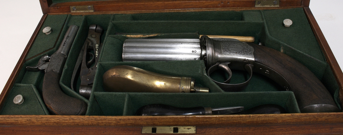 Revolver i "cased set", bestående av revolver (Pepperbox), en enkeltløpet perkusjonspistol samt diverse verktøy, alt liggende i mahognykasse. Bestandelene er følgende: 

KASSE av mahogny, 36,6 x 18,6 x 6,6, cm og er forsynt med lokk som har to mesinghengsler i bakkant. På forsiden er det lås med medding nøkkelhullbeslag på forsiden. Nøkkel av jern, ca. 2,9 cm lang. Midt på lokket er det et rundt messingskilt med profilert kant. Skiltets diameter er 3,8 cm. Kassen er indelt i 11 rom hvorav tre er forsynt med lokk med små, hvite gripehåndtak, runde, knappformede med diameter 1,05 cm. Alle rom er trukket med grønn filt. På lokkets innside er klebet produssentens merkelapp.

REVOLVER. Såkalt "Pepperboks". Et revolverende kammerstykke hvor hver kammer utgjør en selvstendig pipe, en forløper for de senere revolveremed kort tønne og langt løp. Kammerstykket (tønne) er 10 cm langt, hver løp har et kaliber på litt underkant av 10 mm. I bakkant er pipene forsaynt med pistong. På utsiden er pipene ca, 1,2 cm fra pistongene, merket fortløpende med nummer 1 - 6 . Mellom pipene er kammerstykket merket vekselsvis med kronet CP og V. Revolveren har overliggendeslaghane med gravert blomsterranke motiver. Bakenfor hanen er det en bevegelig sikringsfløy. Sideblikkene er prydet med graverte blomsterranker,det venstre sideblikket er markert "W.A. BECHWITH LONDON". Avtrekksbøylen er prydet med blomsterranke motiver. Grepsplater av mørkebrunt tre som er filt i rombemønster. Kolbekappen et oval og svakt buet , er kantet med en smal bord og har i midten et gravert, rundt lokk innenfor hvilket er et lite rom for kuler og fenghetter. Grepet har et lite firkantetntommeskilt med brutte hjørner. Alle beslag er av stål. 

PISTOL. Enkeltløpet, total lengde 13,2 cm. Pipen har et kaliber som revolveren. Pipen er 5,4 cm lang og er stemplet med kronet CP og V. Slaghanene står midt oppå pistolen, stikkende opp mellom sideblikkene. Hanen har skjellmønstret dekor og er forsynt med et par øyne. Når hanen spennes, felles en avtrekker fram under under pistolen. Sideblikkene er dekorert med blomsterranker. Den høyre sideblikket er merket "LONDON" og det venstre "H.BECHWIT ", Grepet er av tre,mørkebrunt og er filt i rombemønster. På grepet sitter et ovalt tommeskilt. 
KRUTTFLASKE. Av messing, 11,4 cm lang, flaskeformet, noe flattrykt mot den nedre delen hvor  det vider seg ut i bredden. Festeskrue og fjær for lukkemekanisme er av stål. 
LADE7PUSSESTOKK. av gulfarget med  et 4,6 cm riflet mesinghode. Total lengde 17,6 cm. Vekt.: 14g. 
KULETANG. Av jern, 8,6 cm lang, merket "1". Vekt: 45 g. 
KULETANF. Av jern, 11,5 cm lang, merket "82". Vekt: 44 g. 
PISTOLNØKKEL. For fjerning og innsetting av pistonger på revolveren. 11,3 cm langt og med sortlakkert treskaft. Vekt. 17 g.