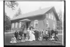 Mo skola, skolbyggnad i bakgrunden.
Skolbarn med lärarinna fröken Anna Larsson.