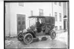 Droskbil.
Droskägare Emanuel Eriksson. 
Bilen är en Darracq från 1910. Den hade reg.nr. O129 och inregistrerades den 3:e november 1910. Den ägdes då av Anders Skog i Göteborg, som var återförsäljare för bland annat Darracq-bilar.