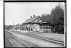 Hjortkvarns Järnvägsstation, envånings stationsbyggnad, åtta personer på plattformen.