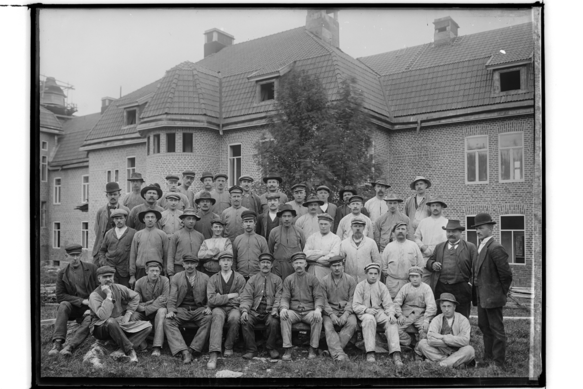 Garphytte Sanatorium, två och en halvvånings sjukhusbyggnader i sten.
Arbetargrupp 44 män. 
Andra raden uppifrån, tredje personen från höger i skärmmössa och med mustasch är muraren Vitus Westman (1884-1963) från Hjo.