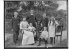 Familjegrupp 7 personer.
Från vänster på bilden: Holger, mamma Lovisa, lille Harry, pappa Adrian, Olle, lille Torsten och Agnes. 
Adrian Asplund, Vasstofta 6. Huset byggt 1911.