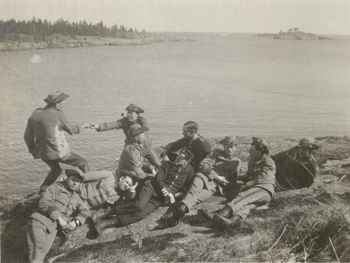 Vilopaus vid stranden. Soldater från Göta livgarde I 2 vilar och drar fingerkrok på stranden.