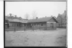 Örebro Köttbesiktningsbyrån, envånings vinkelbyggd träbyggnad.
En man framför huset.
Stadsvetrenär H.Von Delwig