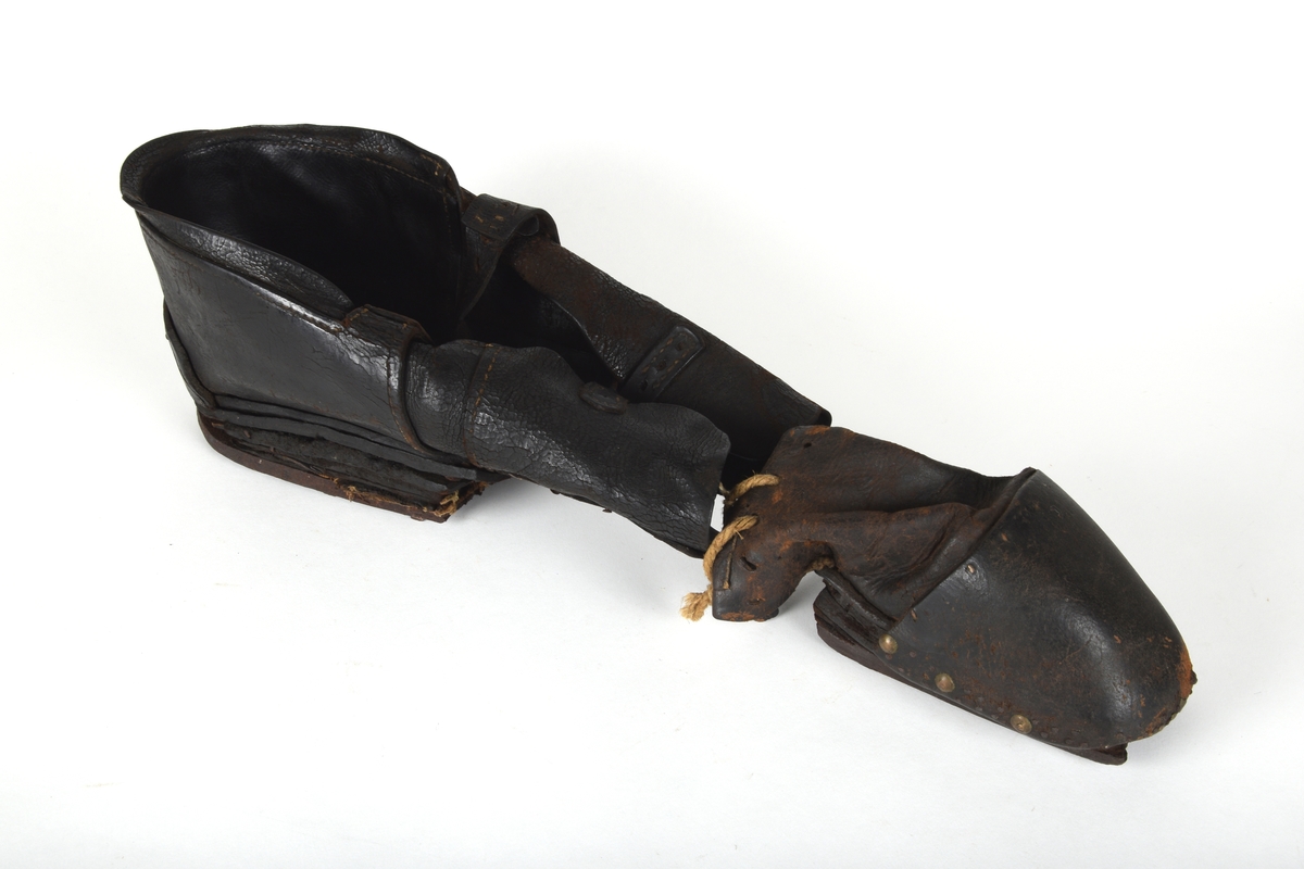 Et par spesialsko med lærreimer som festes til knærne. De består av to deler til kne/legg og to deler til fot/tær. Skoene er laget til en handikappet mann som gikk på knærne.

Leggskoene har jern på undersiden, festet med 6 hesteskosømmer. To spenner med reimer for festing til legg.

Tåskoene har to jern på undersiden, på den ene festet med 7 hesteskosømmer. Den andre har 6 hesteskosømmer og tau for snøring.