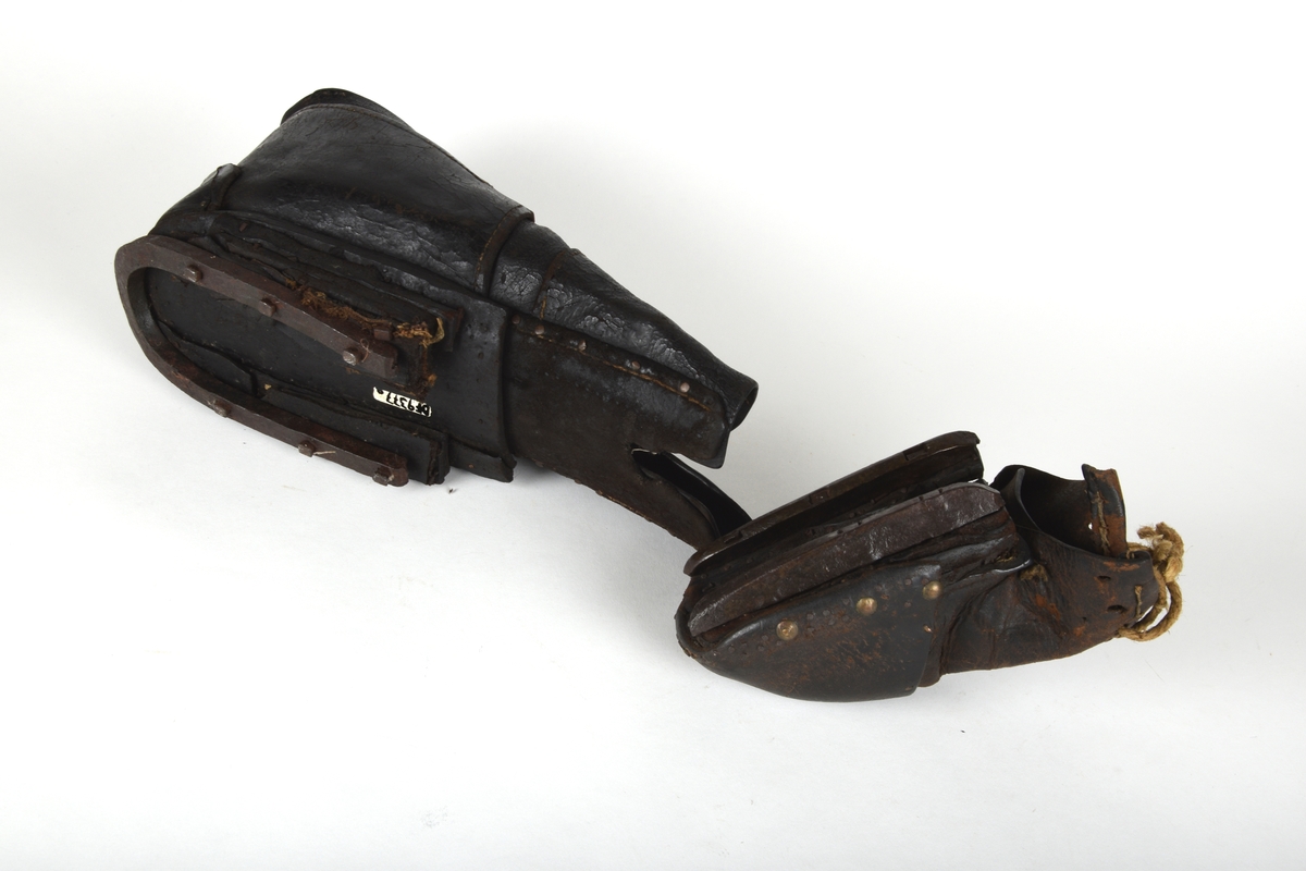 Et par spesialsko med lærreimer som festes til knærne. De består av to deler til kne/legg og to deler til fot/tær. Skoene er laget til en handikappet mann som gikk på knærne.

Leggskoene har jern på undersiden, festet med 6 hesteskosømmer. To spenner med reimer for festing til legg.

Tåskoene har to jern på undersiden, på den ene festet med 7 hesteskosømmer. Den andre har 6 hesteskosømmer og tau for snøring.