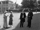 Ärkebiskop Erling Eidem med sällskap utanför Universitetshuset, Uppsala. I bakgrunden skymtar Ärkebiskopsgården