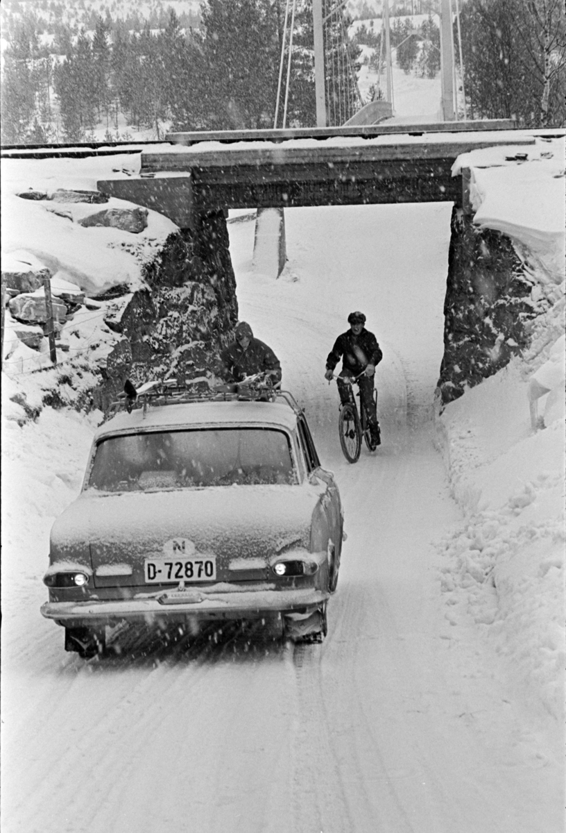 Jernbaneundergang, personbil D-72870, syklister, vinter,snøvær, Kveberg bru, Alvdal. Bilen er en Vauxhall Victor serie FB årsmodell 1961-64.