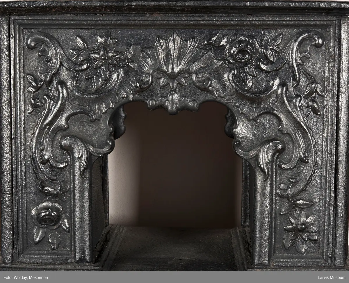 Ovn i  2 etasjer. 
Rokokko, jfr. nr 411 i Norsk Jernskulptur b II 
1. etasje langside: Mars sitter på en kanon med sverd i høyre hånd. Riflet bunn.
1 etasje kortside: Øverst: Rokokko-ornament, nederst: Grevekrone monogram. FL og 1756 
nederst: ovnsdør 2 hengsler ovalt askebrett med profilert kant.
2.etasje langside: Fyldig rokokko-ornament. med blomster. Uregelemessig portalåpning. 
2. etasje kortside: Rokokko-ornament, 
Ovnen har sungne ben m/dyreføtter