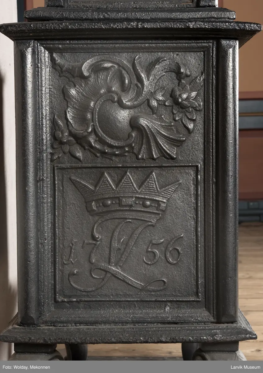 Ovn i  2 etasjer. 
Rokokko, jfr. nr 411 i Norsk Jernskulptur b II 
1. etasje langside: Mars sitter på en kanon med sverd i høyre hånd. Riflet bunn.
1 etasje kortside: Øverst: Rokokko-ornament, nederst: Grevekrone monogram. FL og 1756 
nederst: ovnsdør 2 hengsler ovalt askebrett med profilert kant.
2.etasje langside: Fyldig rokokko-ornament. med blomster. Uregelemessig portalåpning. 
2. etasje kortside: Rokokko-ornament, 
Ovnen har sungne ben m/dyreføtter