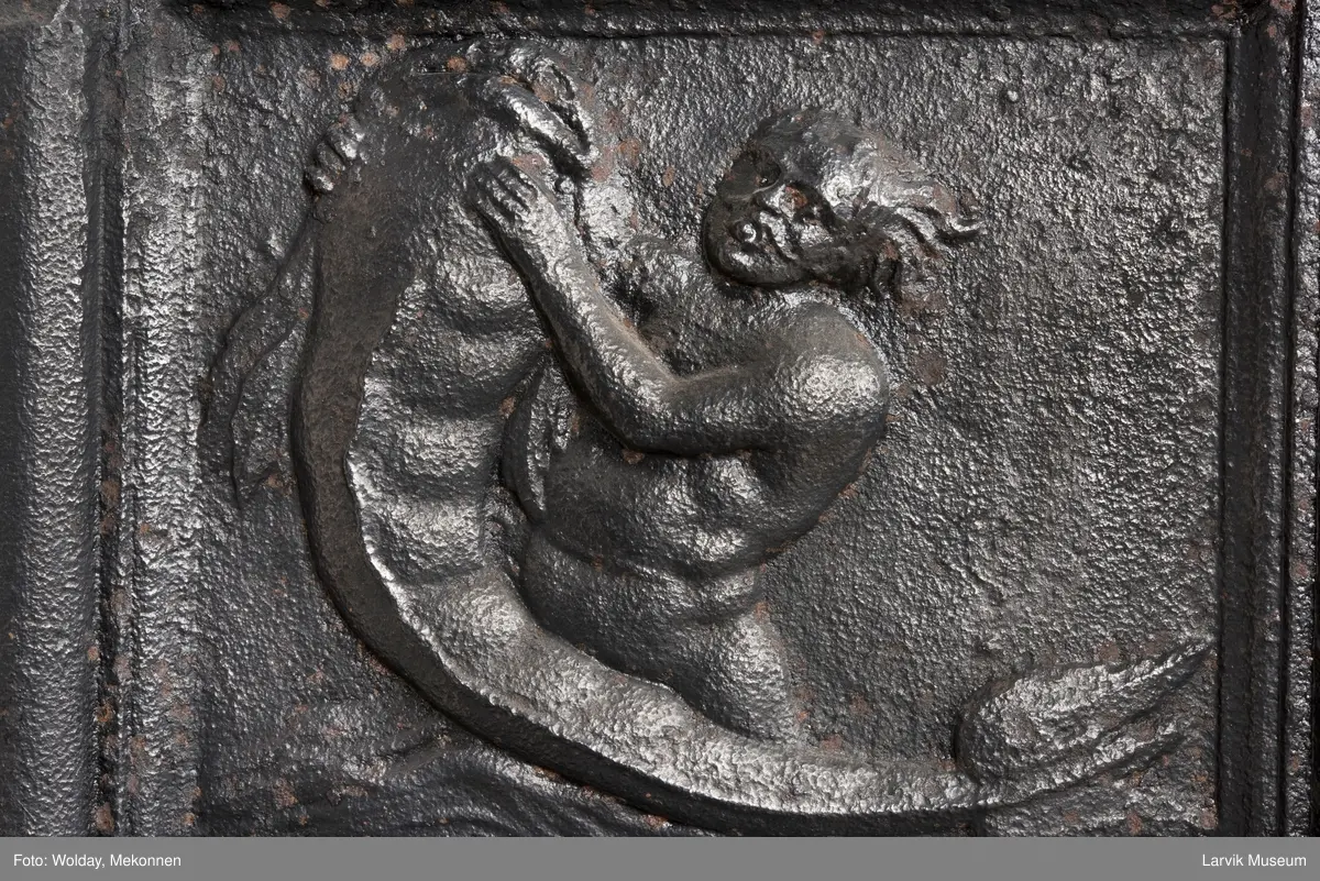 1. etasje langside: Neptun kjører på havet, trukket av hester,løver og kjeruber. riflet bunn.
1. etasje kortside; øverst Triton med delfin, nederst grevekronet i speilmonogram CCDL og 1766, som står for Christian Conrad Danneskiold - Laurvig 
2. etasje langside: Rokokko-ornament med delfin på hver side. profilert portalåpning. 
2 etasje kortside. Triton.