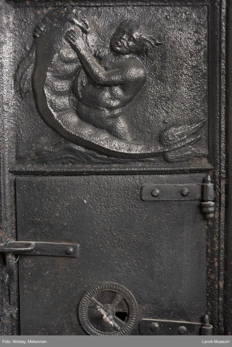 1. etasje langside: Neptun kjører på havet, trukket av hester,løver og kjeruber. riflet bunn.
1. etasje kortside; øverst Triton med delfin, nederst grevekronet i speilmonogram CCDL og 1766, som står for Christian Conrad Danneskiold - Laurvig 
2. etasje langside: Rokokko-ornament med delfin på hver side. profilert portalåpning. 
2 etasje kortside. Triton.