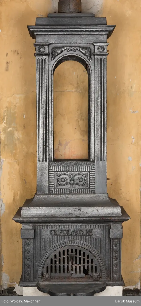 Ovn med avtrappet topp, ovalt, bølget askebrett. 
1. etasje langside: halvsirkelformet. Døren er hengslet i underkant. Over denne på plate står det Fritzøe Wærk. Riflet bunn, lisener med bladverk ved hjørnene. 1. etsje kortside: Rosett, riflet bunn, 
2. etasje langside: Rundbuet åpning, lister til 4 etasjeplater. Over åpning 2 overflødighetshorn, under palmett i riflet ramme. kannelserte pilastre i hjørnene. 2. etasjekortside: Rosett på riflet bunn, bølgemeander.