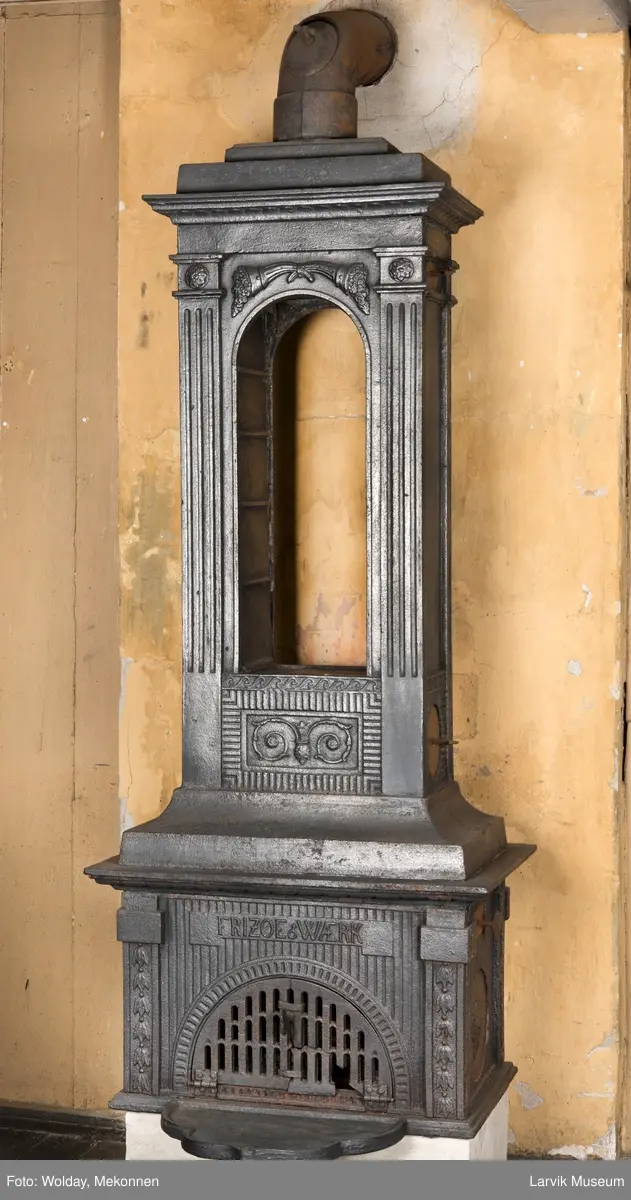 Ovn med avtrappet topp, ovalt, bølget askebrett. 
1. etasje langside: halvsirkelformet. Døren er hengslet i underkant. Over denne på plate står det Fritzøe Wærk. Riflet bunn, lisener med bladverk ved hjørnene. 1. etsje kortside: Rosett, riflet bunn, 
2. etasje langside: Rundbuet åpning, lister til 4 etasjeplater. Over åpning 2 overflødighetshorn, under palmett i riflet ramme. kannelserte pilastre i hjørnene. 2. etasjekortside: Rosett på riflet bunn, bølgemeander.