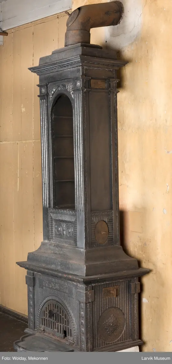 Ovn med avtrappet topp, ovalt, bølget askebrett. 
1. etasje langside: halvsirkelformet. Døren er hengslet i underkant. Over denne på plate står det Fritzøe Wærk. Riflet bunn, lisener med bladverk ved hjørnene. 1. etsje kortside: Rosett, riflet bunn, 
2. etasje langside: Rundbuet åpning, lister til 4 etasjeplater. Over åpning 2 overflødighetshorn, under palmett i riflet ramme. kannelserte pilastre i hjørnene. 2. etasjekortside: Rosett på riflet bunn, bølgemeander.