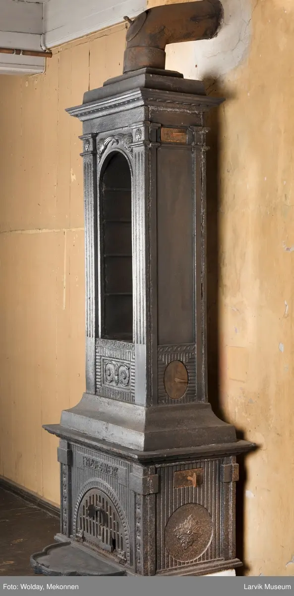 Ovn med avtrappet topp, ovalt, bølget askebrett. 
1. etasje langside: halvsirkelformet. Døren er hengslet i underkant. Over denne på plate står det Fritzøe Wærk. Riflet bunn, lisener med bladverk ved hjørnene. 1. etsje kortside: Rosett, riflet bunn, 
2. etasje langside: Rundbuet åpning, lister til 4 etasjeplater. Over åpning 2 overflødighetshorn, under palmett i riflet ramme. kannelserte pilastre i hjørnene. 2. etasjekortside: Rosett på riflet bunn, bølgemeander.