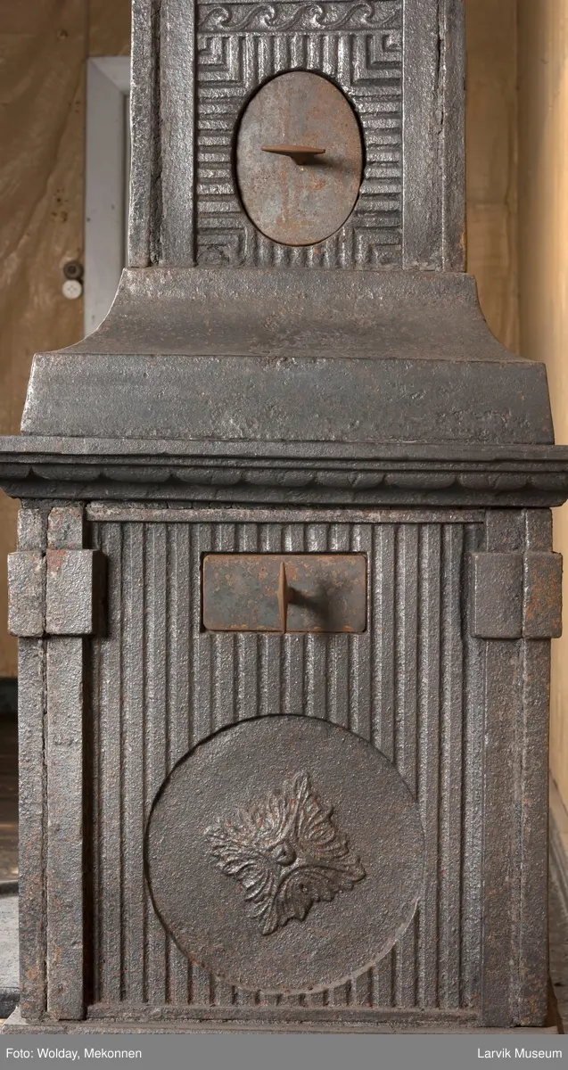 Ovn med avtrappet topp, ovalt, bølget askebrett. 
1. etasje langside: halvsirkelformet. Døren er hengslet i underkant. Over denne på plate står det Fritzøe Wærk. Riflet bunn, lisener med bladverk ved hjørnene. 1. etsje kortside: Rosett, riflet bunn, 
2. etasje langside: Rundbuet åpning, lister til 4 etasjeplater. Over åpning 2 overflødighetshorn, under palmett i riflet ramme. kannelserte pilastre i hjørnene. 2. etasjekortside: Rosett på riflet bunn, bølgemeander.