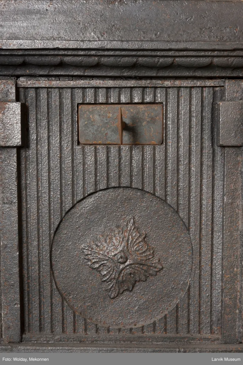 Ovn med avtrappet topp, ovalt, bølget askebrett. 
1. etasje langside: halvsirkelformet. Døren er hengslet i underkant. Over denne på plate står det Fritzøe Wærk. Riflet bunn, lisener med bladverk ved hjørnene. 1. etsje kortside: Rosett, riflet bunn, 
2. etasje langside: Rundbuet åpning, lister til 4 etasjeplater. Over åpning 2 overflødighetshorn, under palmett i riflet ramme. kannelserte pilastre i hjørnene. 2. etasjekortside: Rosett på riflet bunn, bølgemeander.