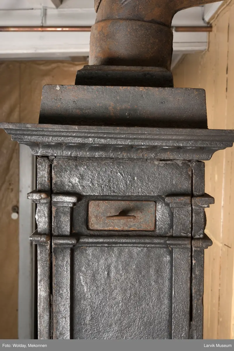 Ovn med avtrappet topp, ovalt, bølget askebrett. 
1. etasje langside: halvsirkelformet. Døren er hengslet i underkant. Over denne på plate står det Fritzøe Wærk. Riflet bunn, lisener med bladverk ved hjørnene. 1. etsje kortside: Rosett, riflet bunn, 
2. etasje langside: Rundbuet åpning, lister til 4 etasjeplater. Over åpning 2 overflødighetshorn, under palmett i riflet ramme. kannelserte pilastre i hjørnene. 2. etasjekortside: Rosett på riflet bunn, bølgemeander.