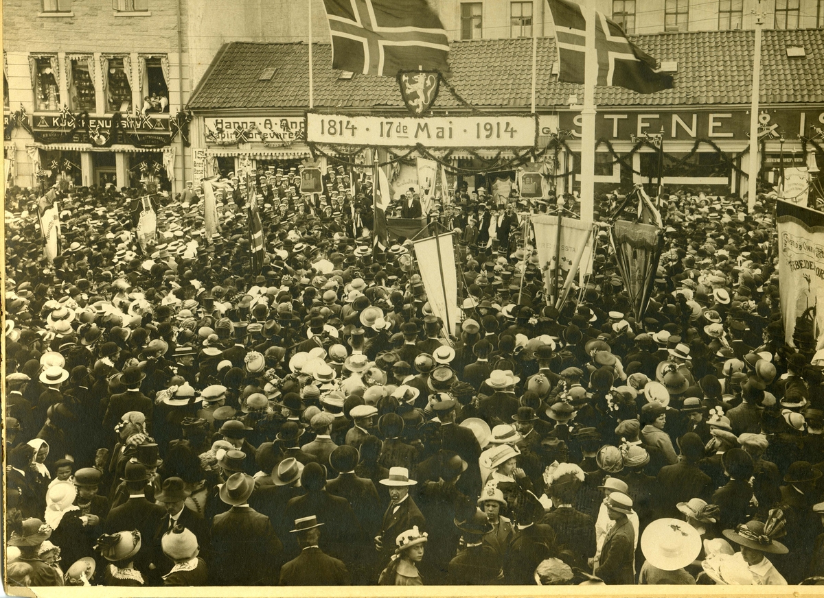 17. mai 1914.
17. maitog.
Grunnlovsjubileum.
Torvet. (Senere: Stortorvet).
Stene & Isaksen.
A. Jensen manufakturforretning.
Hanna A. Andersen kortevareforretning.