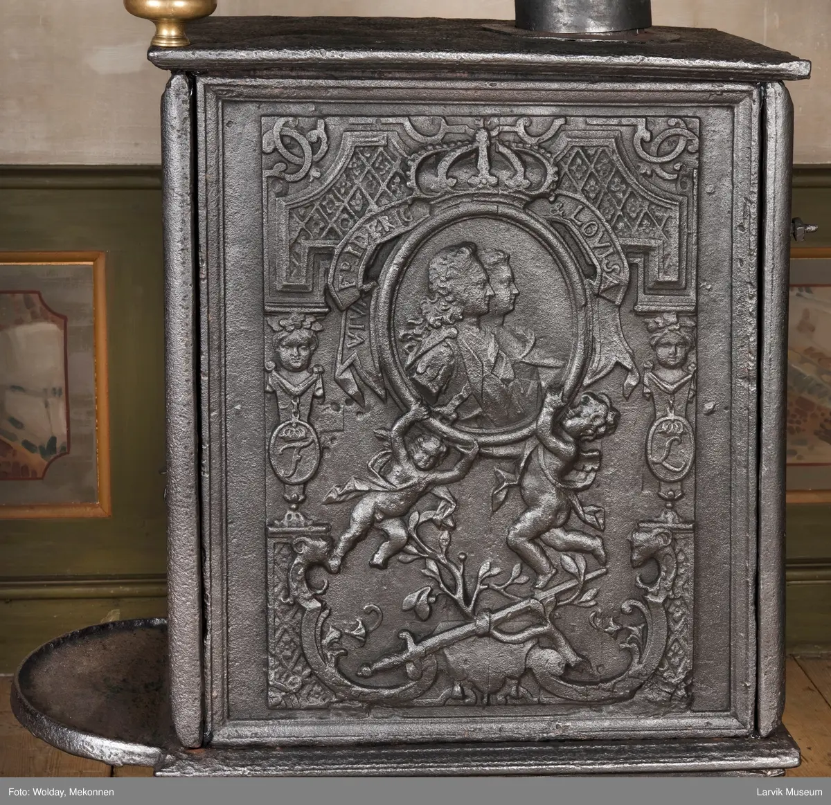 Ovnen har understell, bunnplate, sideplater, frontplate, bakplate og topp, røykkasse, røykerør og to messinghoder. Røykerøret er litt løst.