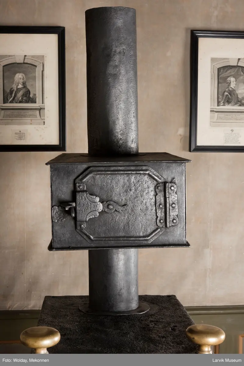 Ovnen har understell, bunnplate, sideplater, frontplate, bakplate og topp, røykkasse, røykerør og to messinghoder. Røykerøret er litt løst.