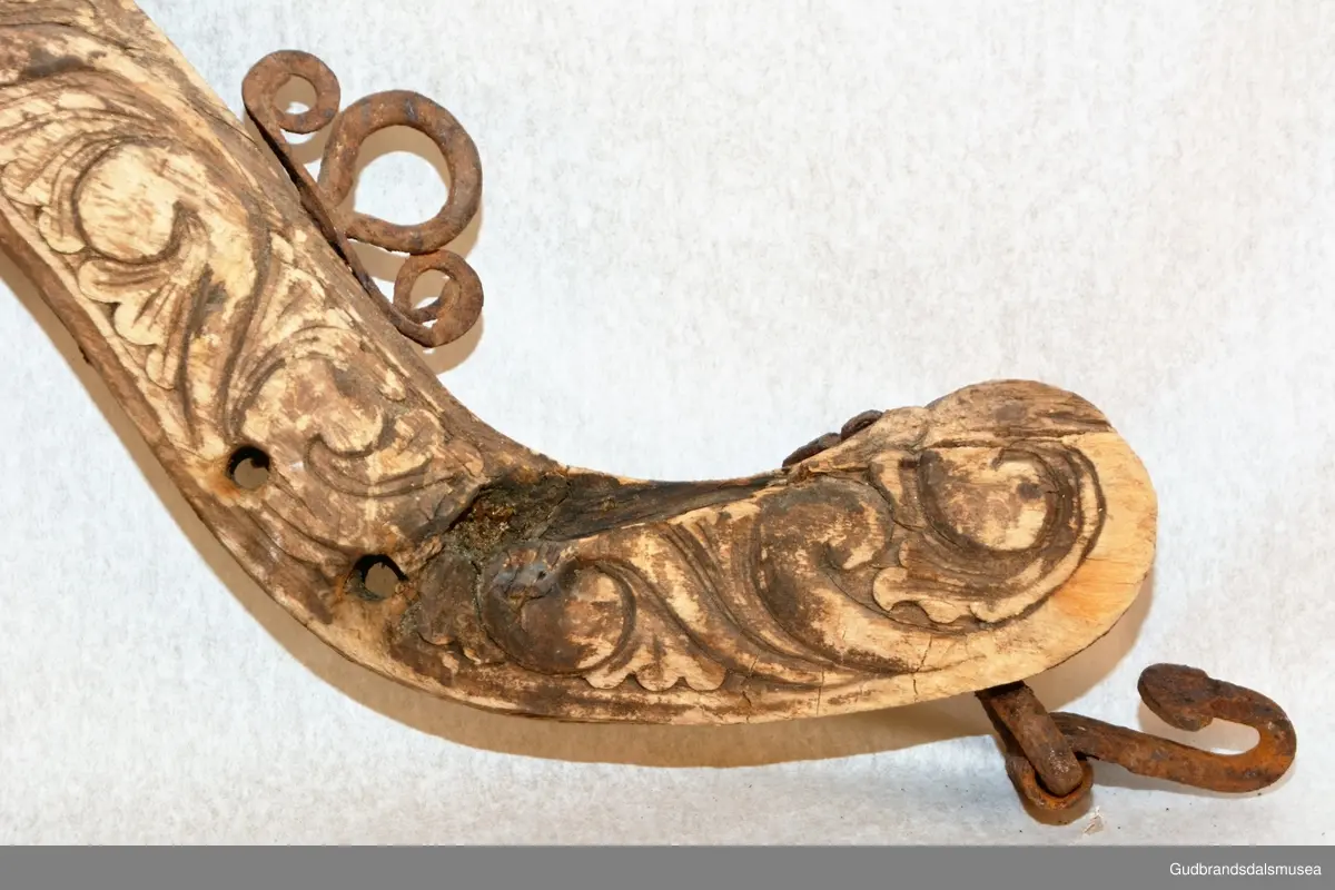 Et par bogtrær med drått og orering i jern. Høvre med ringer av jern for tømmer, to fester av jern for oppholdsreimer, jernbøyle for ryggreim.
DEKOR. Sammenhengende akantusranke i barokkstil med mye bladverk. Den forenklede akantusskurden er et stiltrekk som hører hjemme på slutten av 1700-tallet, begynnelsen på 1800-tallet. (Se også LBY0150b; LBY0151a, b). Inskripsjonen på dråtten P J S E 1827 står antakelig for Peder Johannessen Enstad, f. 1798, d. 1828, gardbruker på Sørpå Enstad fra 1820. Årstallet 1827 antas å være produksjonsåret for høvret og bogtreet.
BRUK. Høvre og bogtre hører sammen. De utgjør de primære festeanordningene for seletøyet og medvirker til å fordele trekkbelastningen på en hensiktsmessig måte. Høvren er plassert fremme over ryggen på hesten. Den har huller eller ringer som tømmene blir ført igjennom og er i tillegg festepunkt for rygg- og bære-/oppholdsreimer. Bærereimene går videre nedover og er koplet til draget/skåken.
Bogtrærne er festet til hverandre over nakken med en nakkereim og rundt brystet med en brystreim. Midt på treet er det hull for feste av dråtten. Dråtten, en 6-7 cm. bred, stiv lærreim, blir i motsatt ende festet til draget/skåken.