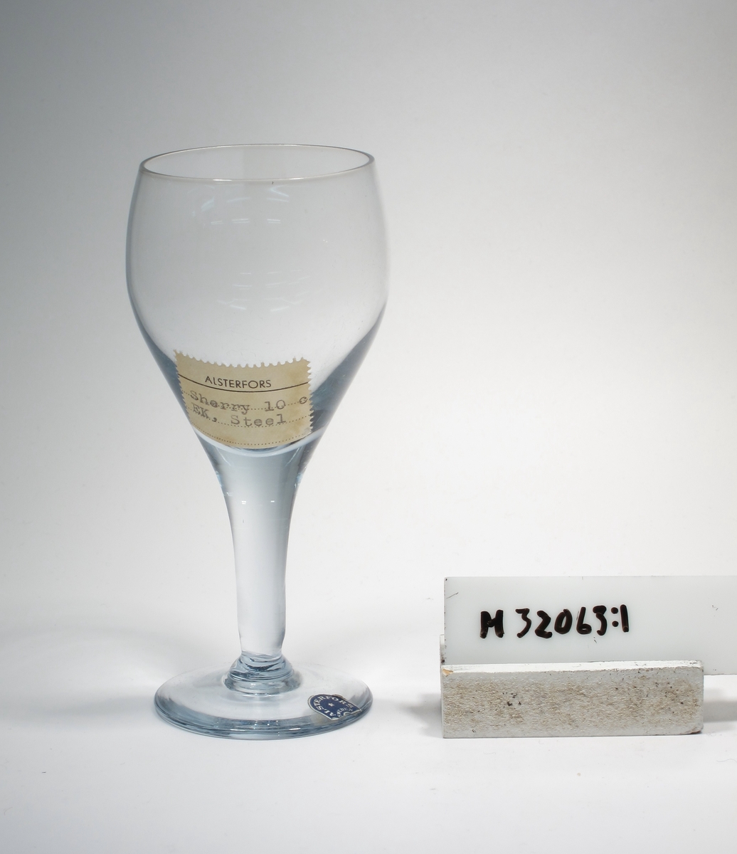 Äggformad kupa, draget koniskt ben, fot.
Etikett: Bågformad, röd med vit text, glasblåsare i mitten: "ALSTERFORS SWEDEN"
Lapp: "ALSTERFORS"
"Sherry 10 c"
"EK, Steel"