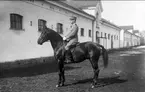 Strömsholmskursen 1916. Ridning på Strömsholm på Stallplan mellan lilla ridhuset (till vänster) officersstallet (till höger), hingstridhuset och hingststallet.