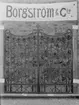 Borgström & Cie. Smidd grind med blommönster, grinden krönt av ett kors. Utställningsplåtar 1925