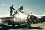En flygförare kliver i/ur flygplan J 29 tillhörande F 3 Malmen. En flygtekniker står på flygplanets vinge.