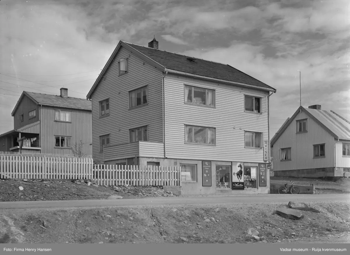 Vadsø sentrum 1952, Oscarsgate 3, bildet er tatt mot nord. Gjenreisningshus med Aksel Niska sin kioskforretning i sokkeltasjen. Boliger i 1. og 2.etasje. Huset øst for Niska tilhørte Natalie Øyen.