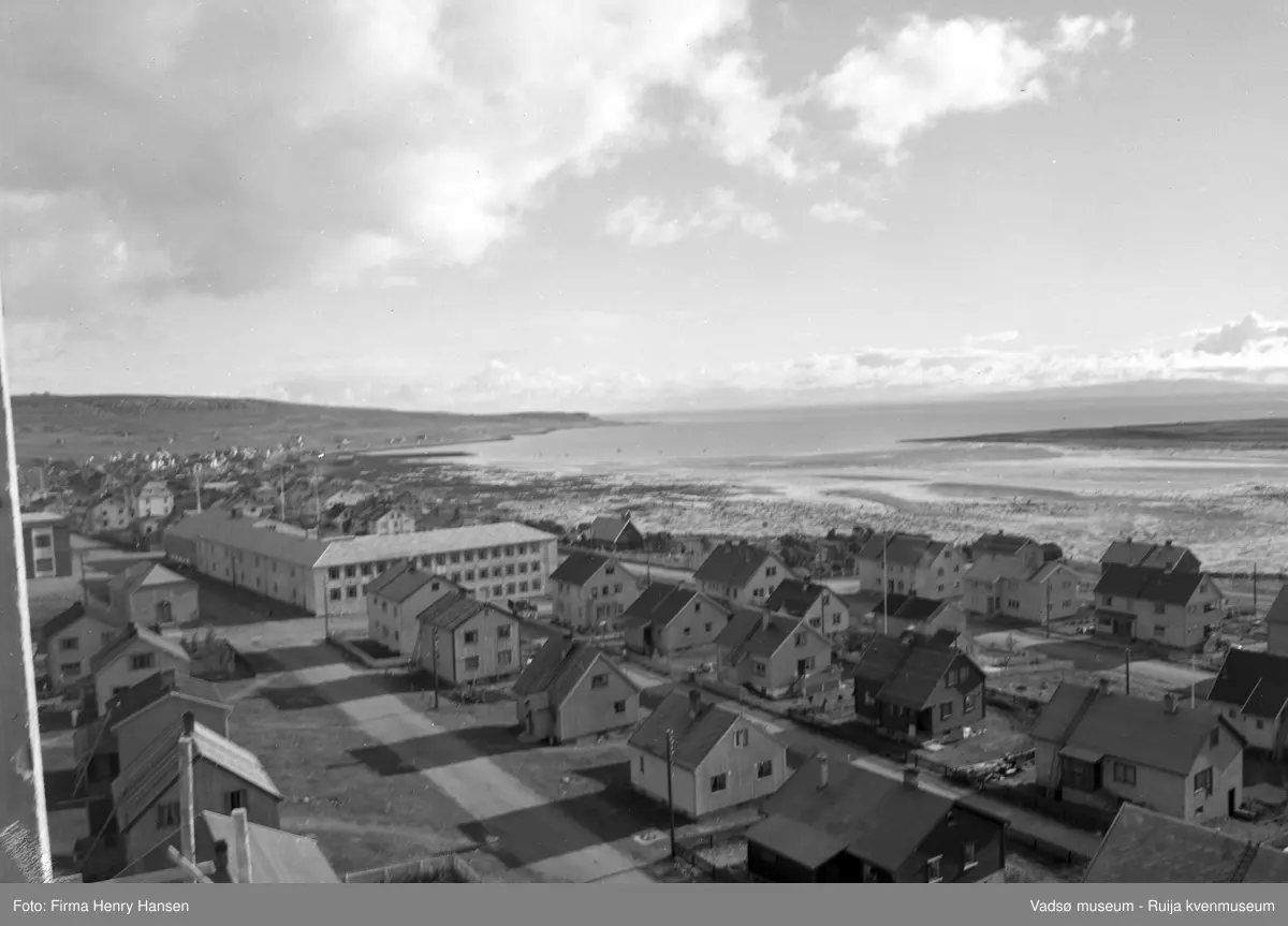 Vadsø 1957. Bildet er tatt fra kirka og østover mot Navarsvingen, man ser sjøen også østspissen av øya.  Barne- og ungdomsskolen midt i bildet, man ser også det læstadianske bedehuset, litt av samfunnshuset, og boliger langs Amtmannsgata, Inspektør Hansens gate og Oscarsgata.