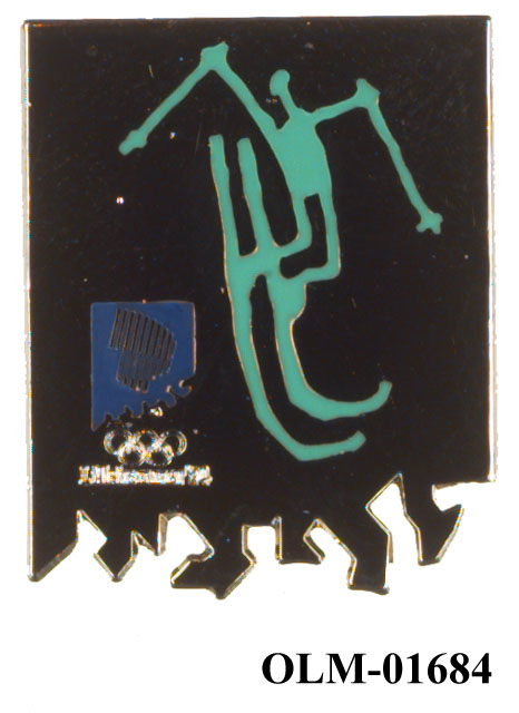 Jakkenål av metall med grønt piktogram for freestyle. Emblem for Lillehammer '94 nederst til venstre over taggete kant.