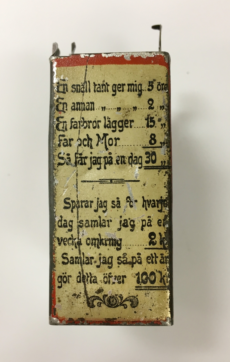 Ur huvudkatalog:
Liten sparbössa, tillverkad av bleckplåt. Den har formen av en gammal brevlåda. Rödlackerad med svart text på framsidan, (baksidan saknar text). Sidorna är vita med svart text. Ovanför "brevinkastet" på framsidan finns en bild av postverkets vapen, en krönt trumpet.